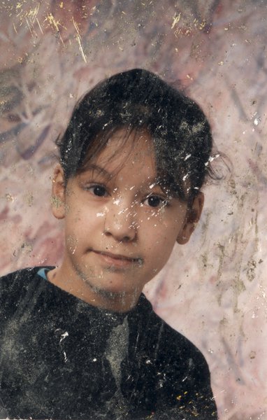 Visage de petite fille brune. Image abîmée.