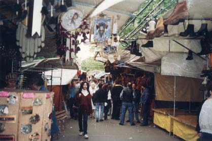 Marché de vêtements et d’objets avec passants.