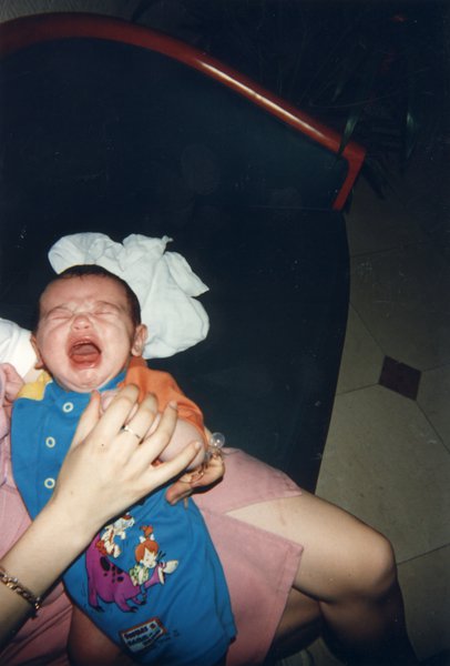 Bébé en grenouillère pleurant.