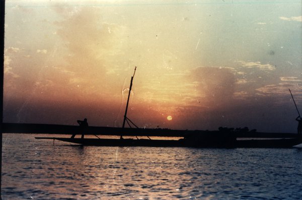 Longue embarcation et coucher de soleil sur la mer.
